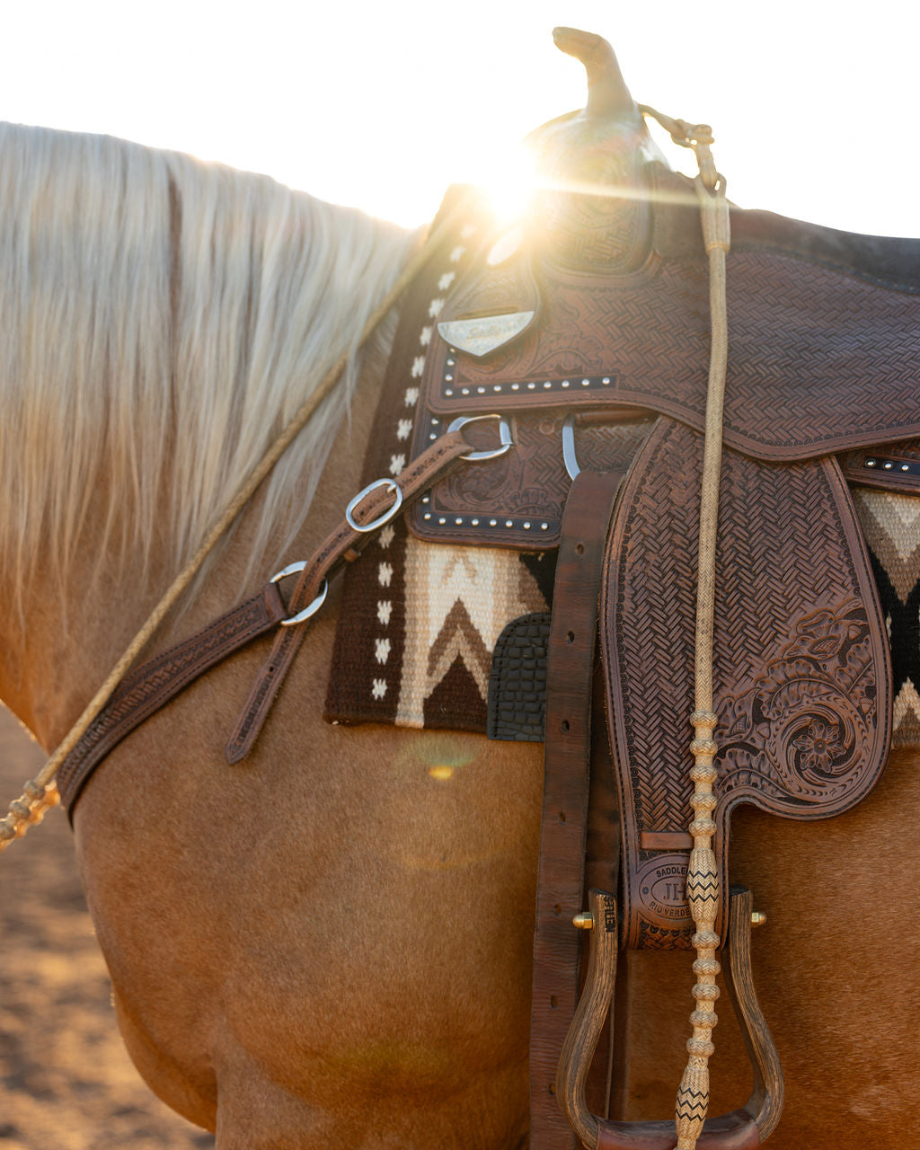 Close-up of a patterned ranch pad beneath a western saddle on a horse